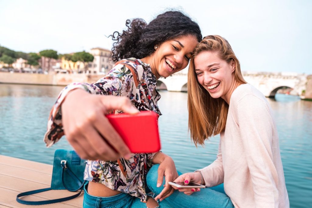 Multiethnic girlfriends taking selfie at city park together - Friendship concept with happy girls at summer city vacation - Female lifestyle concept with millenial women influencer - Vivid filter